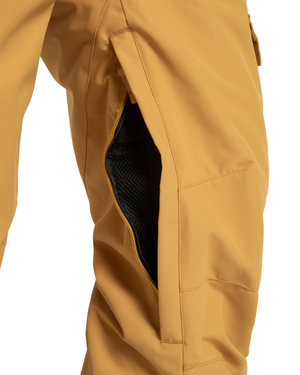 Close-up of DC Shoes Women’s Nonchalant Insulated Snow Pants in mustard yellow, featuring a partially open side zipper that reveals black mesh lining. Made from recycled polyester for sustainability.