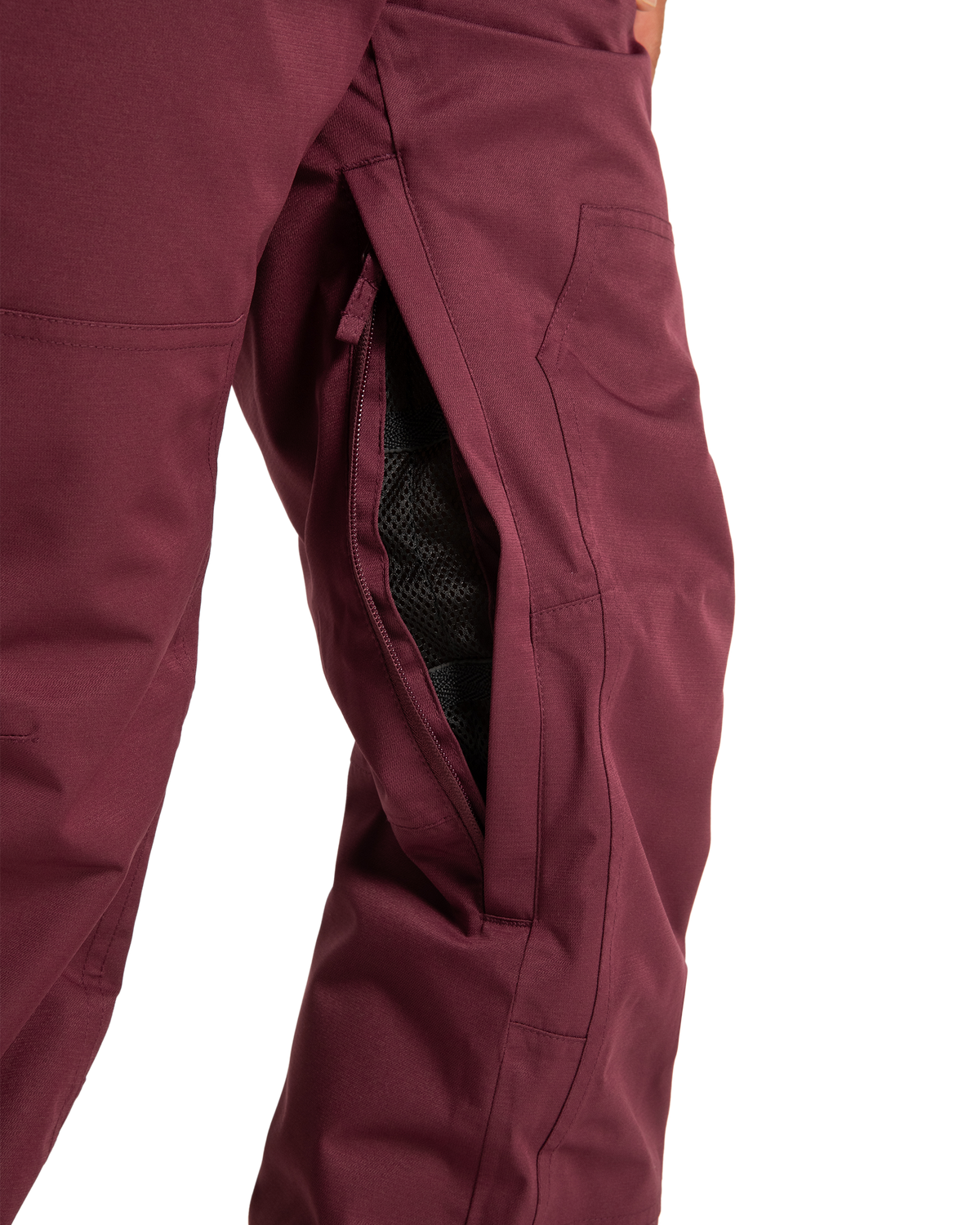 Close-up of DC Shoes Women’s Crusade Shell Bib pants in maroon, featuring a partially unzipped side pocket that reveals the black mesh lining inside.