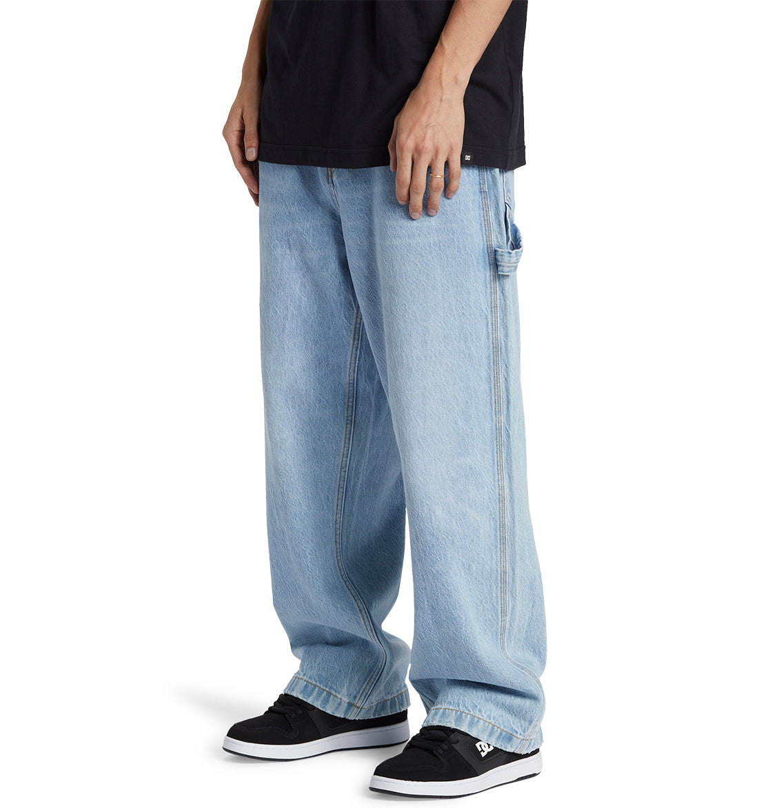 Outfitted in DC Shoes’ Men’s Worker Baggy Carpenter Ril Jeans featuring contrast stitching, styled with a black t-shirt and black DC sneakers with white soles—this look perfectly channels skate culture jeans style.