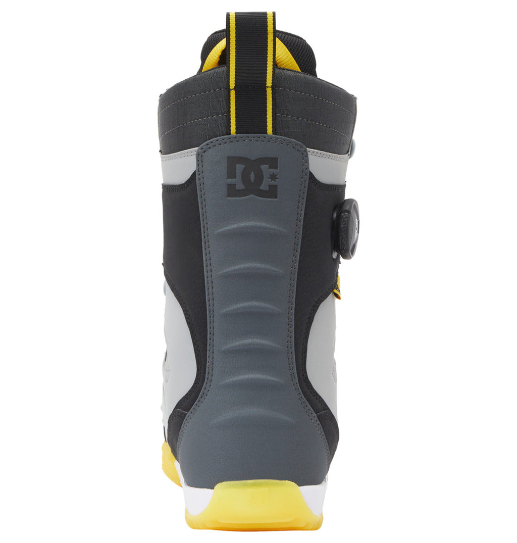 Rear view of the DC Shoes Men’s Premier Hybrid BOA® Snowboard Boot in gray, black, and yellow, featuring the DC logo, ribbed back panel, pull loop, and a yellow sole. This boot is designed with the innovative BOA® Fit System for precise adjustment and exceptional support on the slopes.