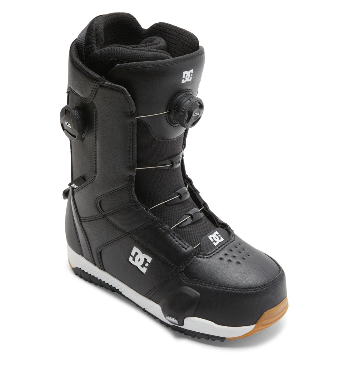 A pair of DC Shoes Men’s Control Step On BOA® Snowboard Boots in black, showcasing the Dual Zone BOA® Fit System for advanced performance, with a white DC logo and brown rubber sole, displayed at an angle on a white background.