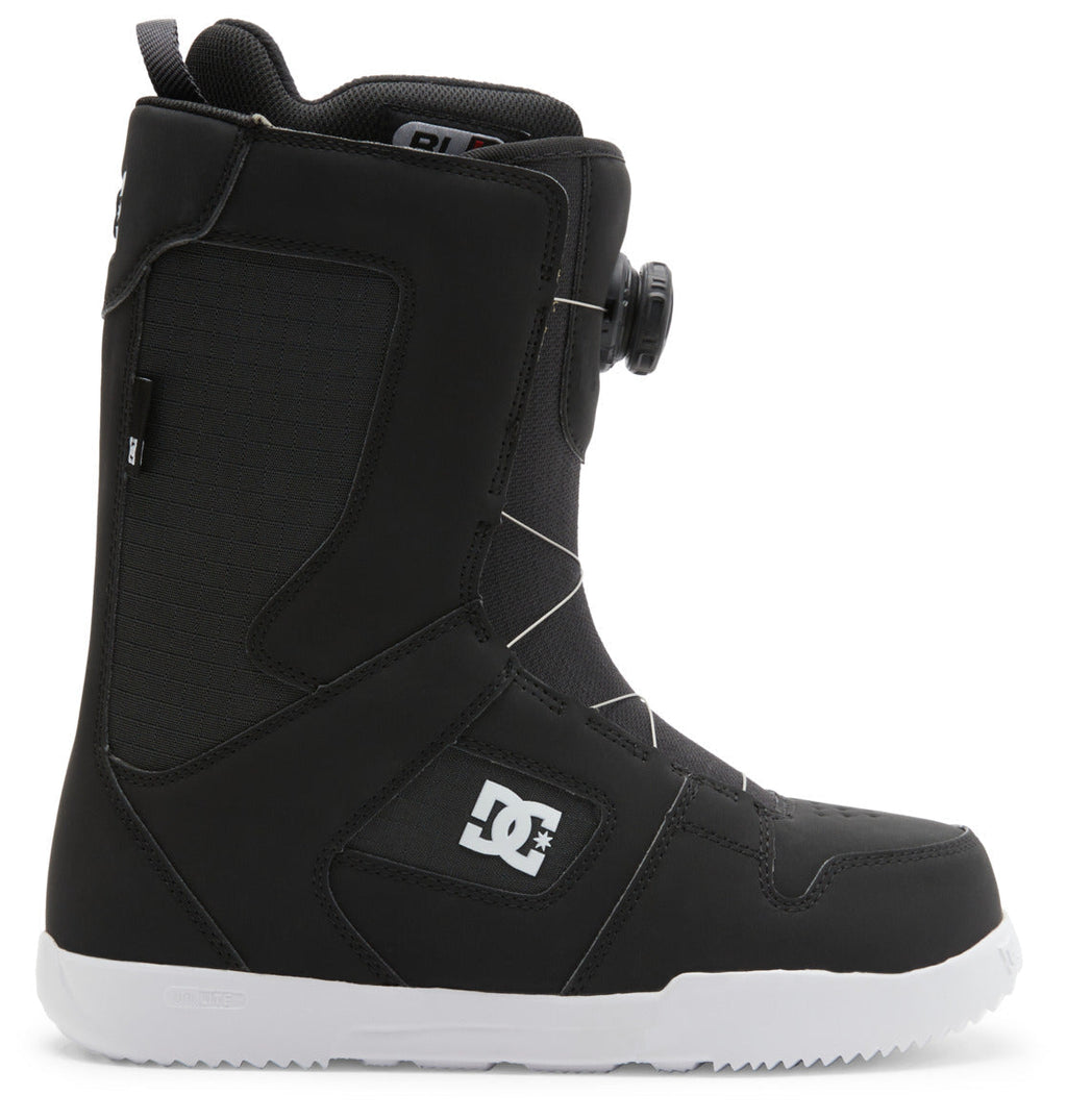 The DC Shoes Men’s Phase BOA® Snowboard Boot is shown in profile facing left against a white background, featuring a black design with IMPACT-ALG insoles, a white sole, side DC logo, and the BOA Fit System dial tightening system.