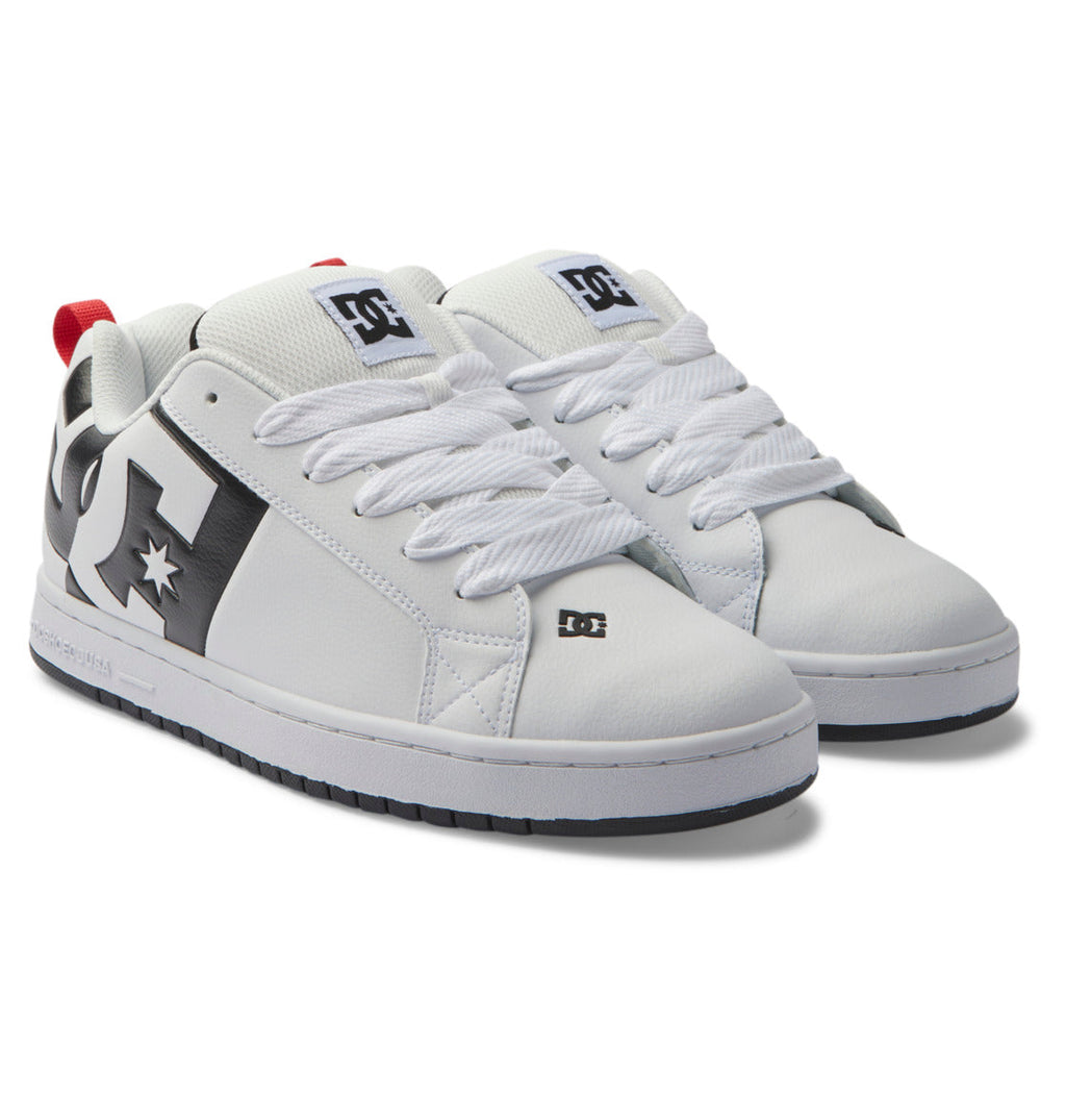 Introducing the Men’s Court Graffik Shoes by DC Shoes: a pair of white men’s skate shoes with bold black accents, striking red heel tabs, thick white laces, and prominent DC Star Logos displayed on the side, tongue, and near the toe. These shoes are completed with a stylish two-tone sole for added flair.
