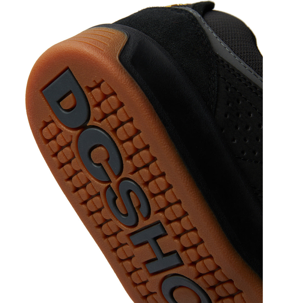 Close-up of the gum sole of a black DC Shoes sneaker with raised tread and bold DCSHOE branding on the bottom, highlighting a signature detail featured in styles like the Men’s Kalynx Zero Shoes.