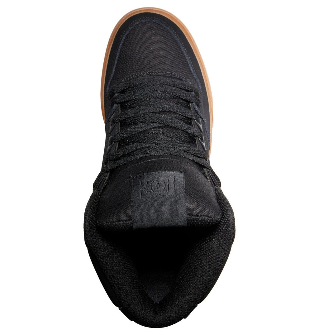 Black skate-style sneaker with a gum sole, shown in a top-down view. The laces are neatly tied, and the tongue displays an embossed DC Shoes logo. Made from fabric and suede for durability and comfort, these Men’s Pure High-Top Shoes are inspired by the iconic Pure SE Hi-Tops.