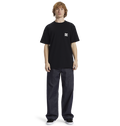 A person with curly hair wears the Men's DC Star Pocket Tee by DC Shoes in black, paired with relaxed fit dark jeans and black shoes, standing against a plain white background.