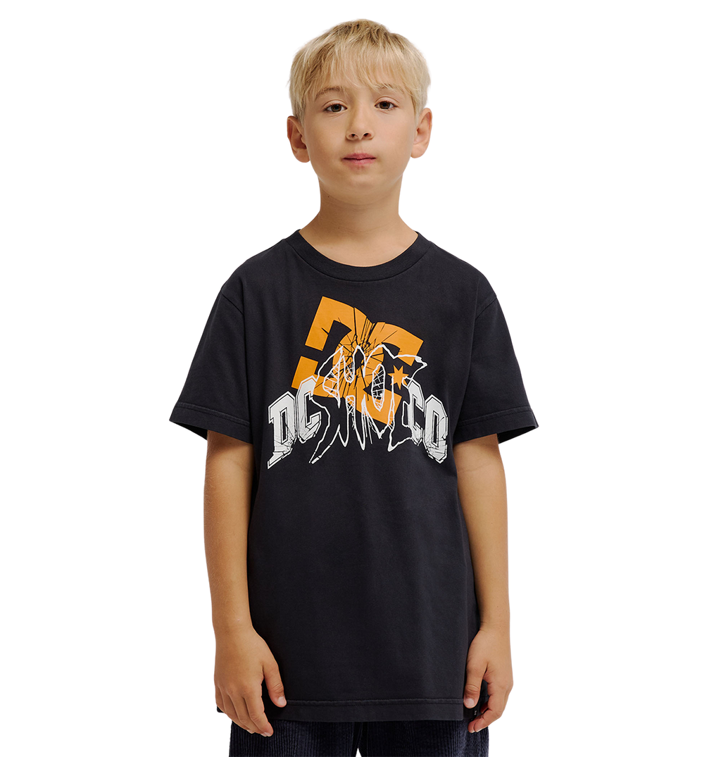 A young boy with blonde hair wears the DC Shoes Speratic Tee Youth, a black graphic skate t-shirt with bold orange and white designs, standing against a plain white background.