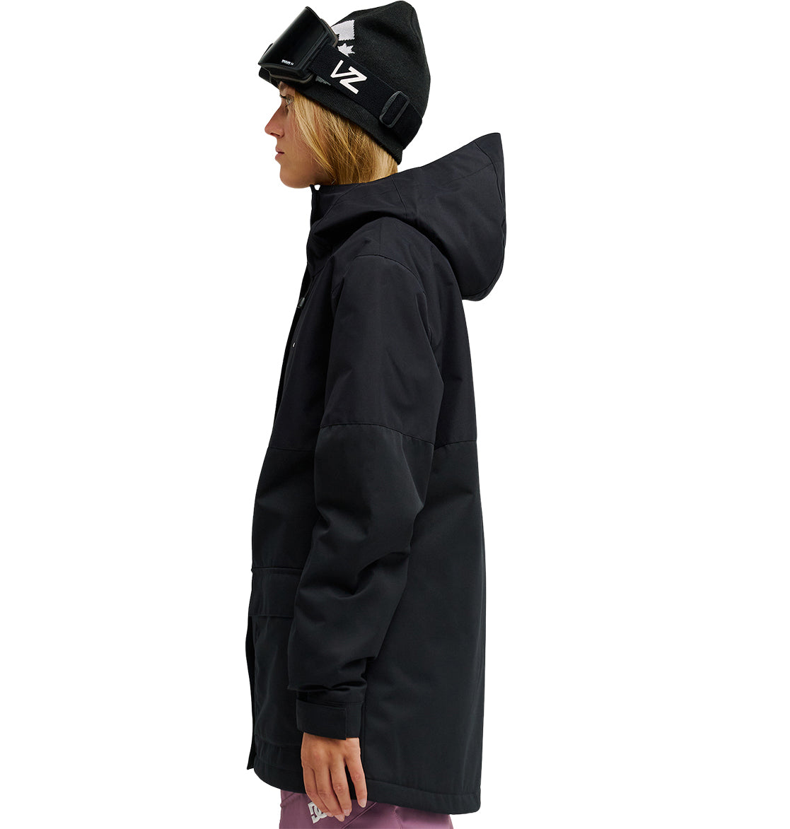 A person wearing a black hooded waterproof Cruiser Jacket from DC Shoes, a black beanie, and ski goggles stands in profile facing left. They are also dressed in purple pants against a white background.