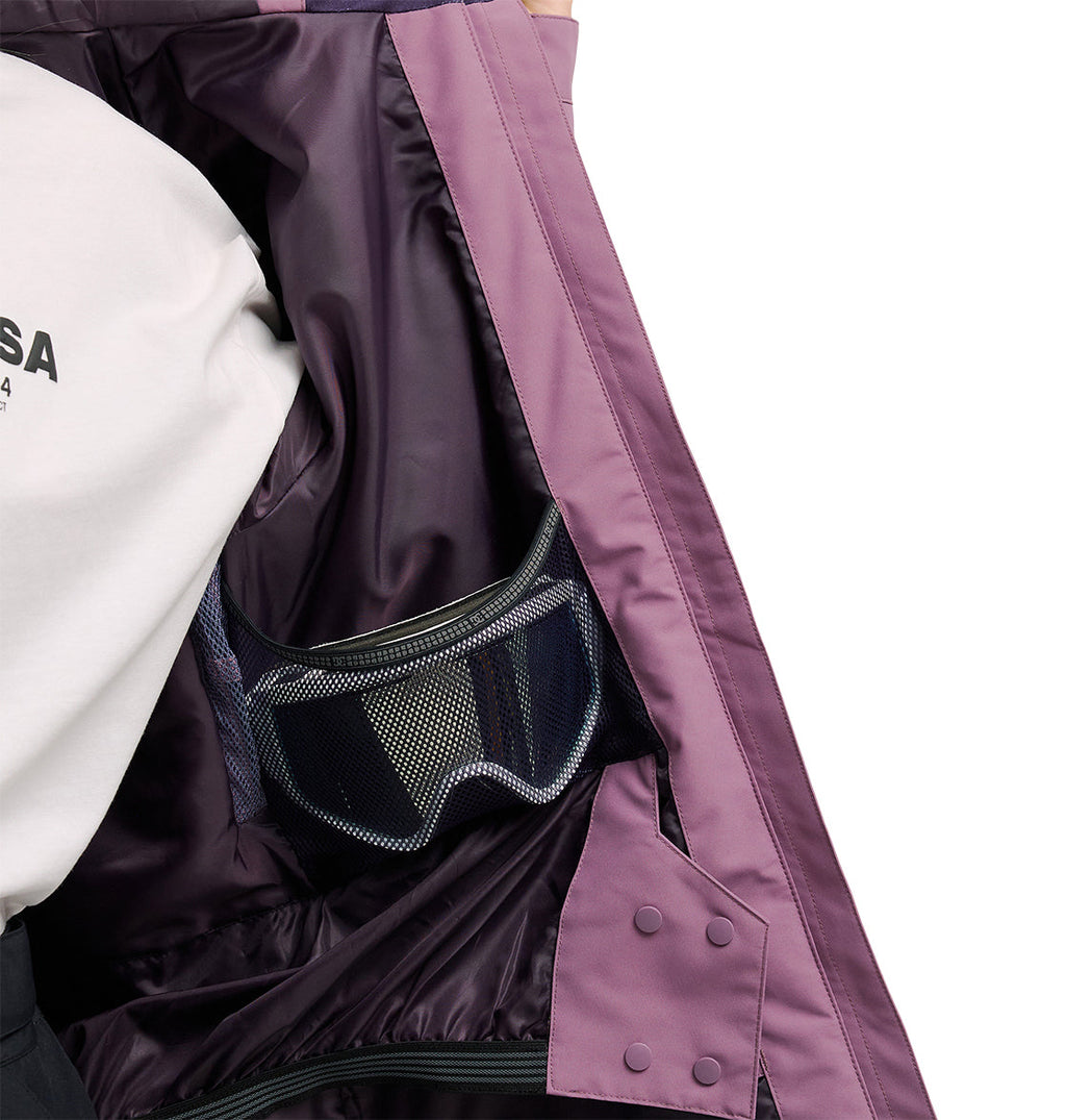 A person wearing a white shirt holds open the DC Shoes Cruiser Jacket in purple, revealing its inner mesh pocket and lining.