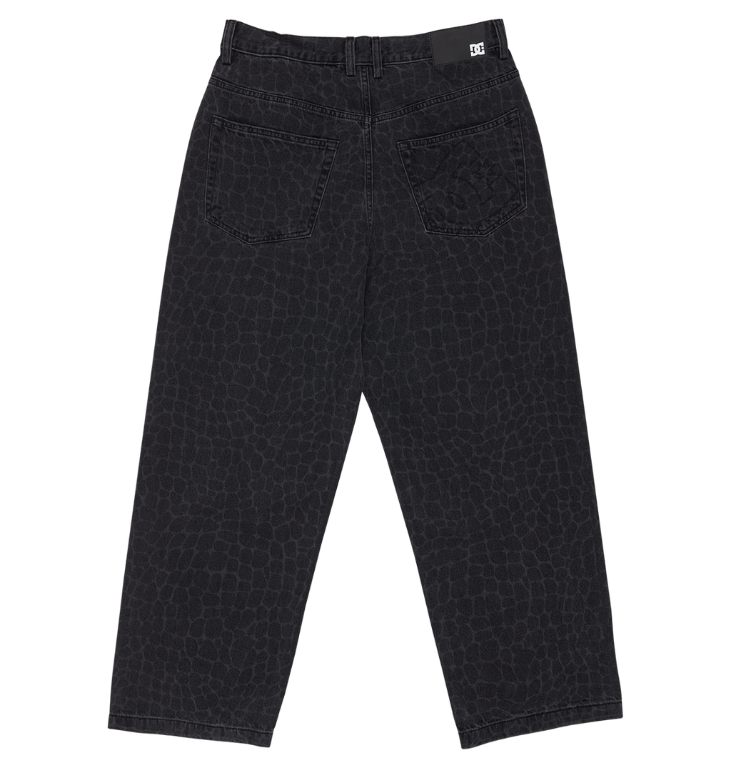 The DC Shoes Men's Baggy Denim Snake Print Pant features black denim with a subtle snake print, two back pockets, belt loop waistband, a logo tag on the right back waist, and a baggy straight fit. Displayed flat on a white background.