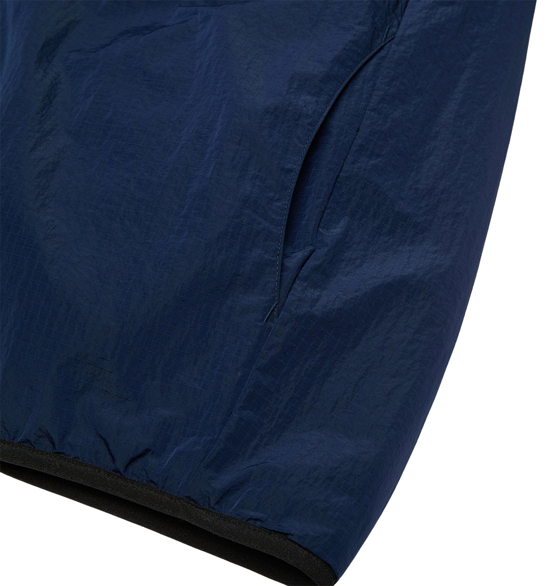 Close-up of the DC Shoes Coldstag Sherpa Reversible jacket sleeve in navy blue, featuring a visible side pocket and elastic cuff, highlighting the lightweight, subtly shiny fabric designed for cold-weather comfort.