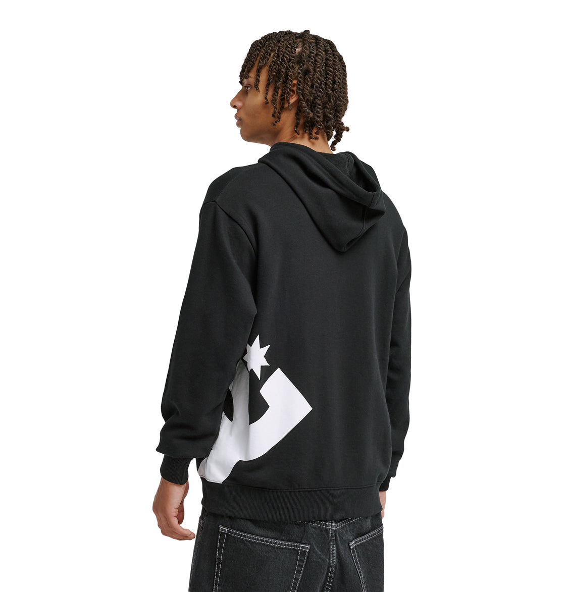 A person with braided hair wears the Reebok Lanai Ph black hoodie featuring a large white graphic on the lower back, paired with dark jeans, standing facing away and looking to the side.