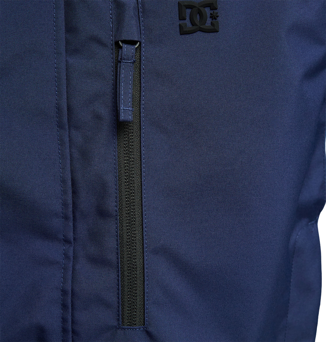 Close-up of the DC Shoes Coldsmoke Jacket 10K in navy blue, highlighting a vertical zippered pocket and a small black DC Shoes logo near the top right, designed with breathable protection for enhanced comfort and performance.