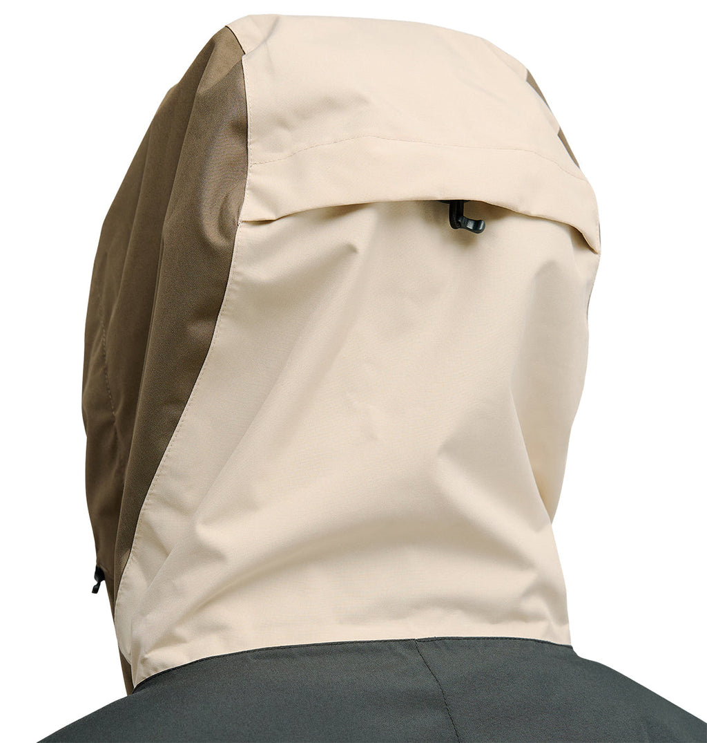 A close-up of the back of the DC Shoes Coldsmoke Jacket 10K in beige and olive green showcases the hood pulled up over the head, with a small black adjustment toggle near the top, highlighting its waterproof design for enhanced protection against unpredictable weather conditions.