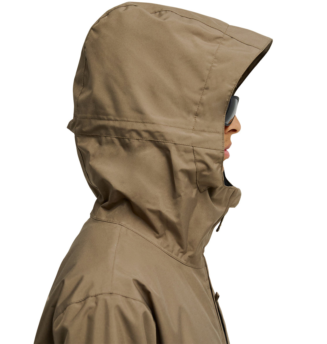 A person is shown in profile view against a plain white background wearing the DC Shoes Basis Jacket 10K, an insulated tan jacket with a hood, along with sunglasses.