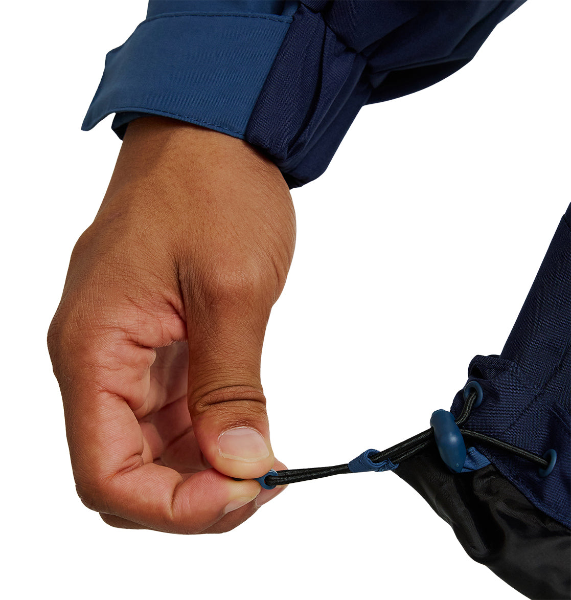 A hand pulling the elastic drawcord at the hem of the DC Shoes Mountain Lab Anorak 10K, adjusting the fit of the dark blue jacket for enhanced breathable protection.