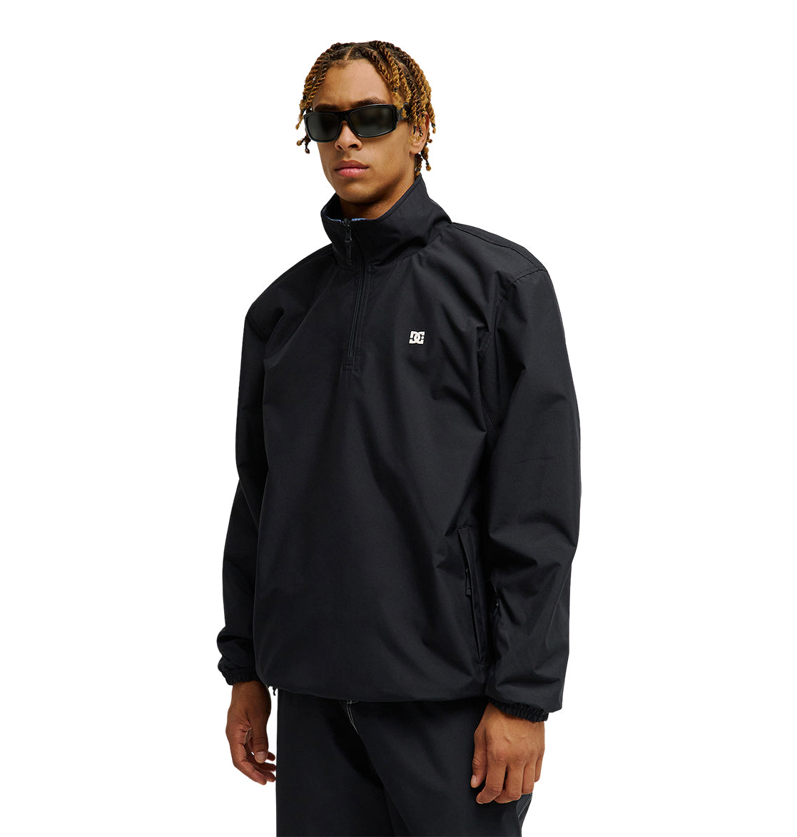A person wearing the DC Shoes Park Reversible Anorak—a black zip-up jacket featuring a small white logo on the chest and engineered for exceptional snow performance—stands against a white background.