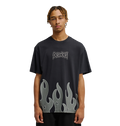 A young man with short braids wears the Men's DC Burning Diamonds Tee from DC Shoes—a black graphic skate t-shirt featuring the iconic Dogshoes logo on the chest and gray flame graphics at the hem, inspired by burning diamonds artwork. He stands out against a plain, light background, looking directly at the camera.
